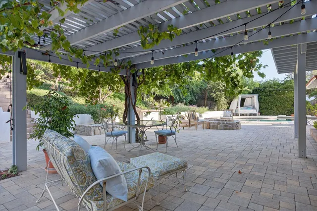 a view of a patio with table and chairs potted plants and tree
