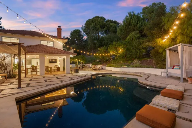 a view of a house with backyard sitting area and garden