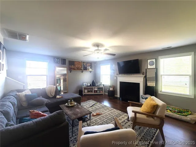 a living room with furniture a fireplace and a window