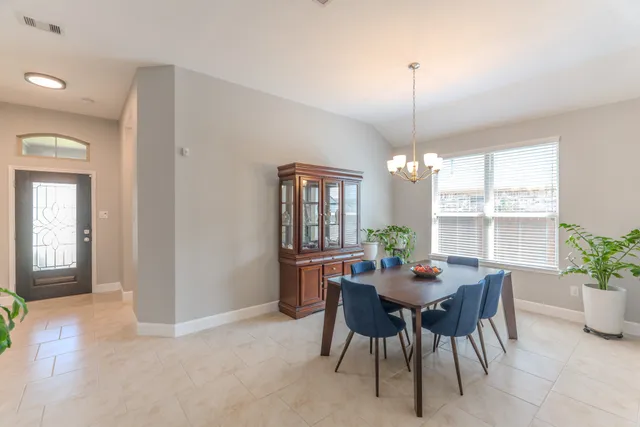 a kitchen with a stove a sink a refrigerator and chairs