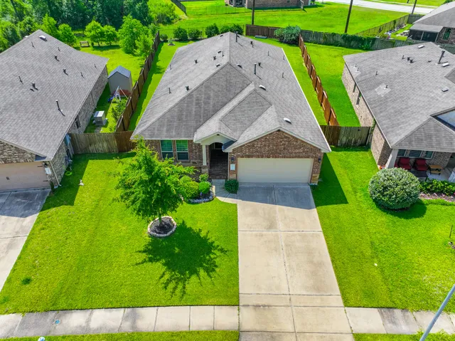 a aerial view of a house with a yard and potted plants