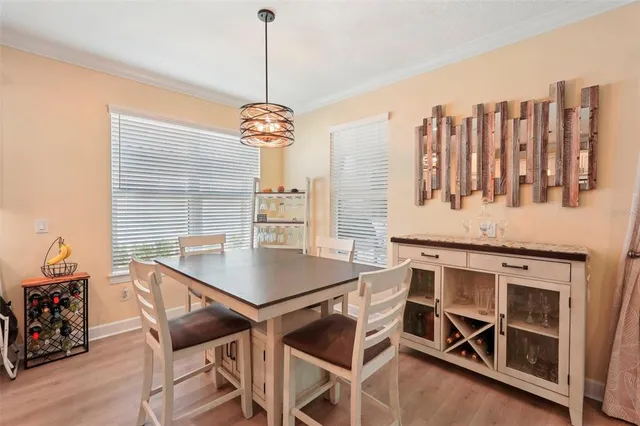 a kitchen with kitchen island granite countertop a table chairs stove and refrigerator