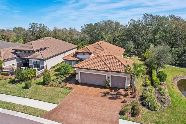 an aerial view of a house with a swimming pool lake view and mountain view