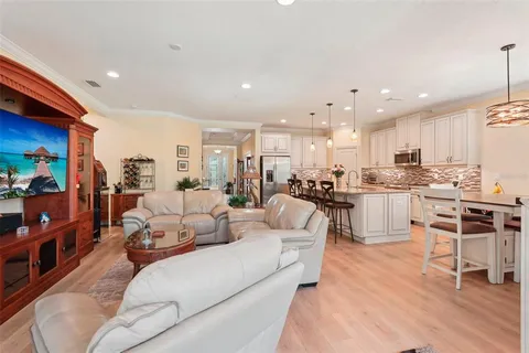 a kitchen with stainless steel appliances kitchen island granite countertop a dining table chairs and white cabinets
