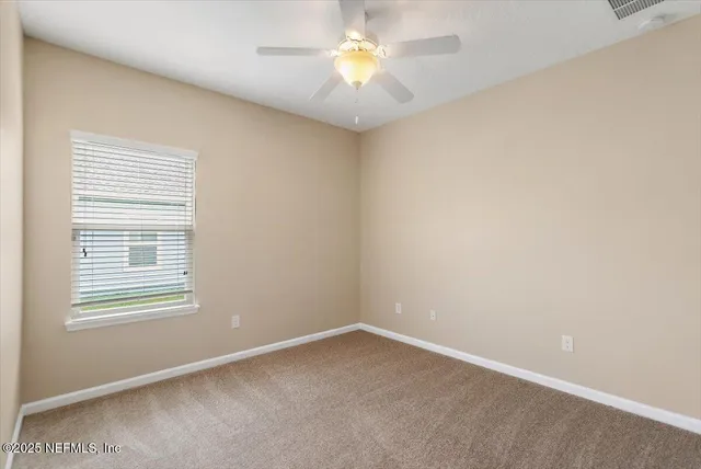 an empty room with a window and a fan
