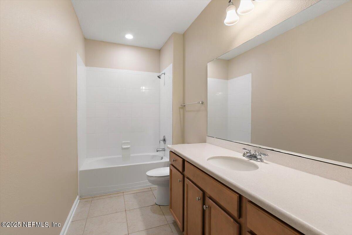 165 Crown Colony Road St. Augustine, FL 32092 - Photo 16 of 25 a bathroom with a granite countertop sink a toilet and shower