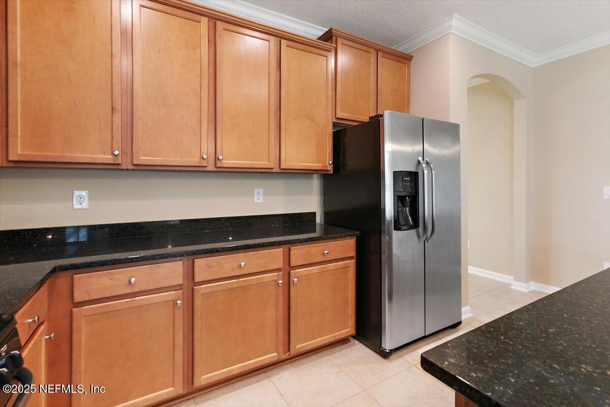 165 Crown Colony Road St. Augustine, FL 32092 - Photo 6 of 25 a kitchen with stainless steel appliances granite countertop a refrigerator a sink and white cabinets with wooden floor