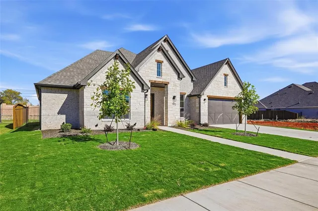 a front view of a house with a yard and trees