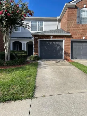 a front view of a house with a garden and garage