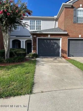 a front view of a house with a garden and garage