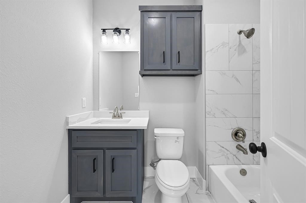 7517 Hezekiah Lane, Unit B Houston, TX 77088 - Photo 12 of 13 a bathroom with a sink a toilet and shower