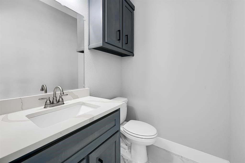 7517 Hezekiah Lane, Unit B Houston, TX 77088 - Photo 5 of 13 a bathroom with a sink a toilet and mirror
