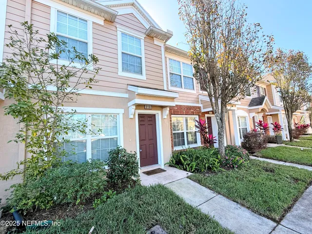 a front view of a residential houses with yard and green space