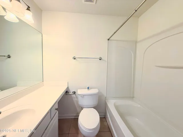 a white toilet sitting next to a bathroom sink and tub