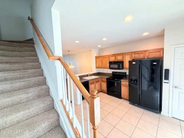a kitchen with stainless steel appliances kitchen island granite countertop a refrigerator and a sink