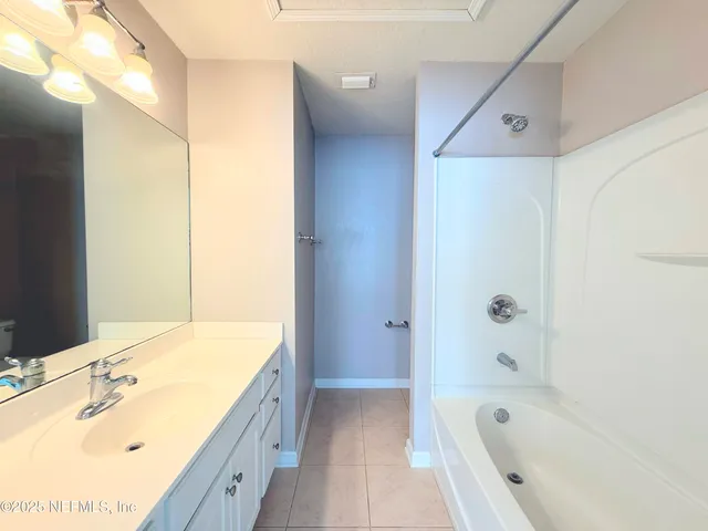 a bathroom with a tub sink and mirror
