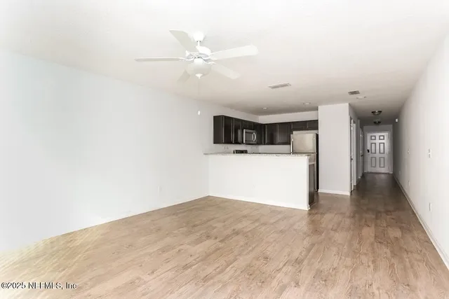 a view of a kitchen with a sink and a refrigerator