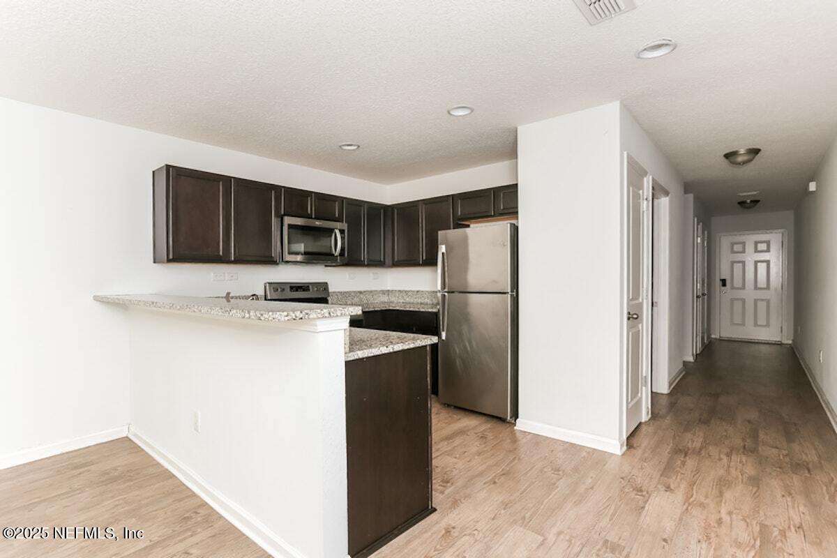 514 Eiseman Way Jacksonville, FL 32216 - Photo 6 of 15 a kitchen with a refrigerator and a microwave
