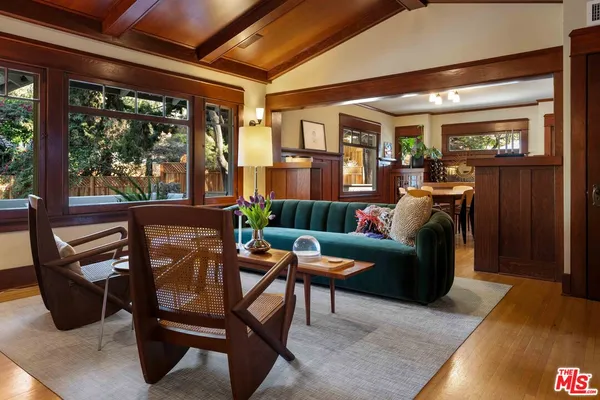 a living room with furniture a floor to ceiling window and wooden floor