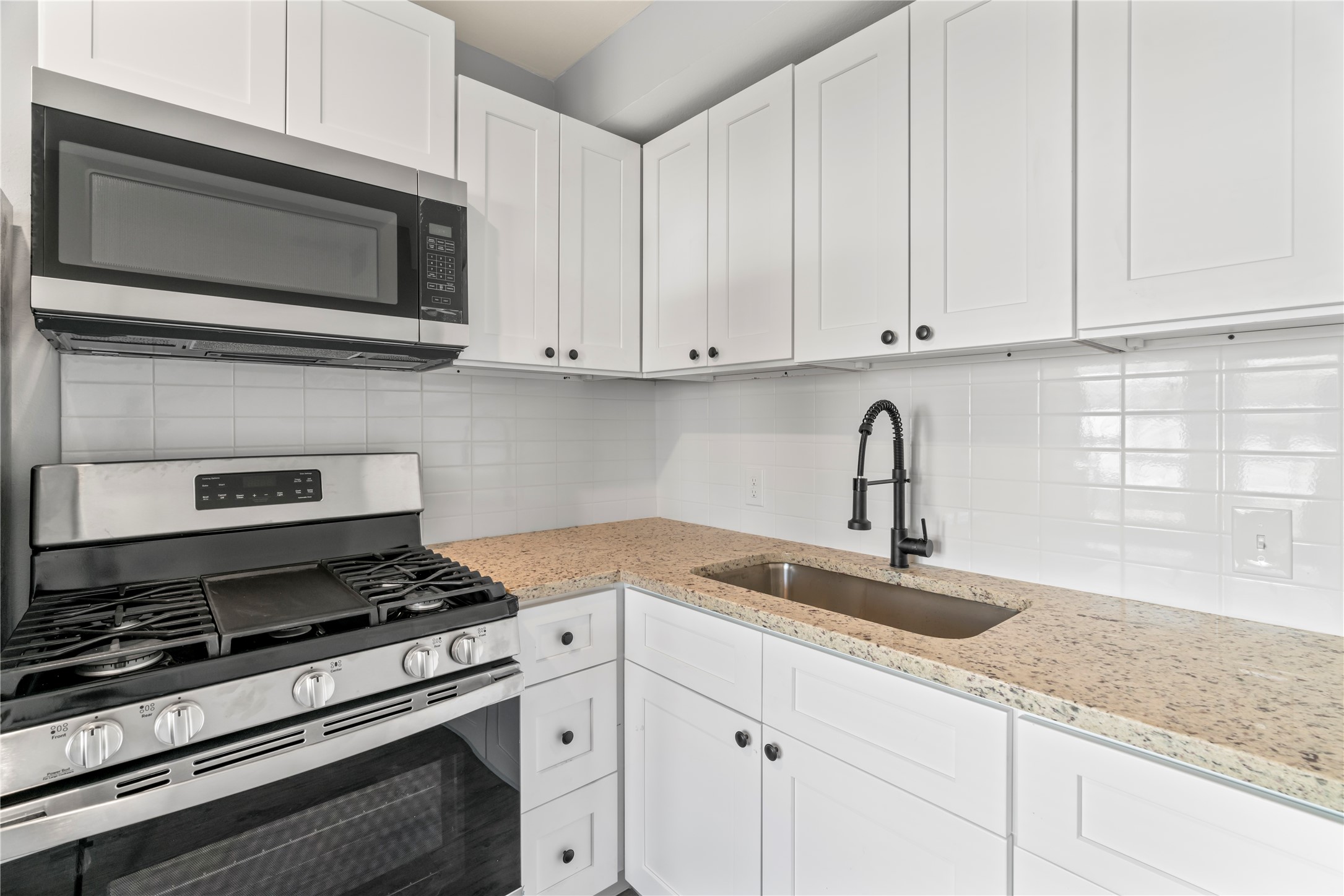 305 Roberts Street, Unit 10 Houston, TX 77003 - Photo 4 of 7 a kitchen with granite countertop a sink and a stove