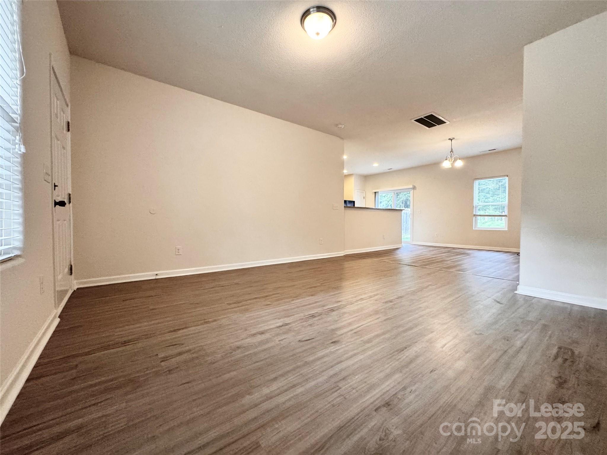 6717 Ware Road Charlotte, NC 28212 - Photo 2 of 22 an empty room with wooden floor and windows