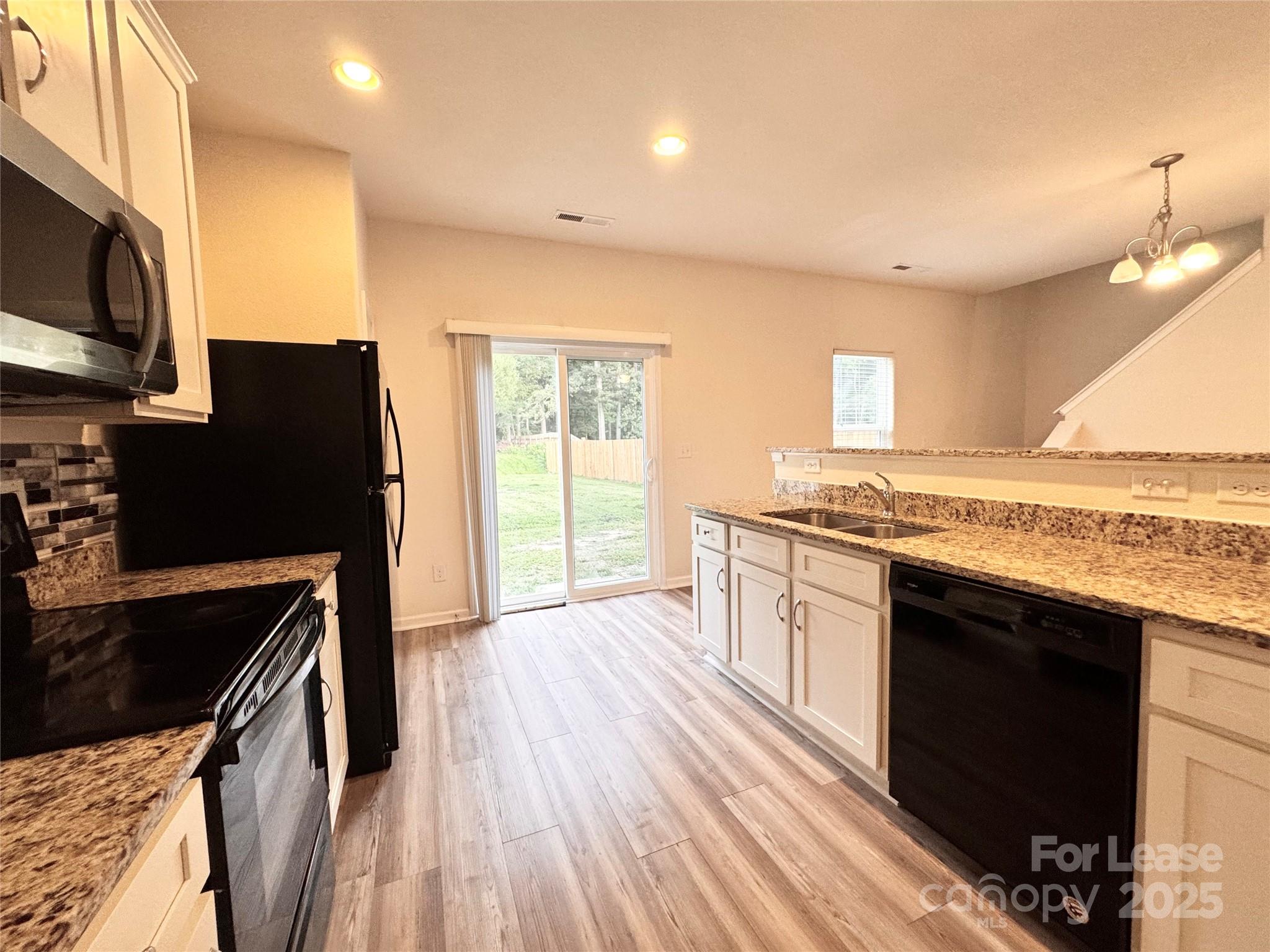 6717 Ware Road Charlotte, NC 28212 - Photo 9 of 22 a kitchen with stainless steel appliances granite countertop a stove a sink and a refrigerator