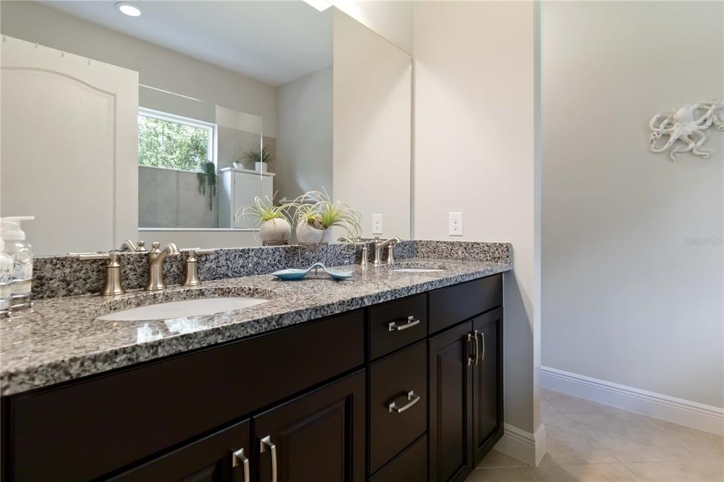 12252 Stuart Drive Venice, FL 34293 - Photo 23 of 70 a bathroom with a granite countertop sink a mirror and a window