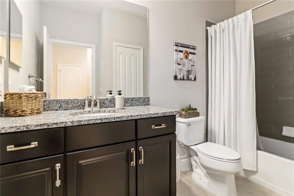 12252 Stuart Drive Venice, FL 34293 - Photo 29 of 70 a bathroom with a granite countertop sink toilet and mirror