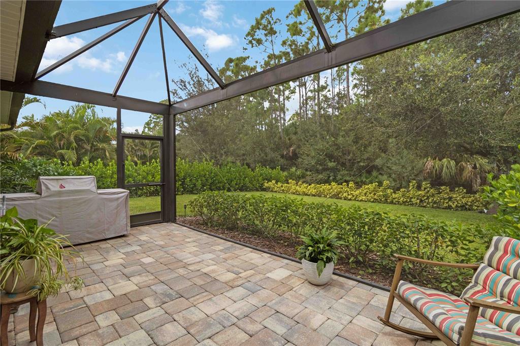 12252 Stuart Drive Venice, FL 34293 - Photo 37 of 70 a view of a patio with a table chairs potted plants and a yard