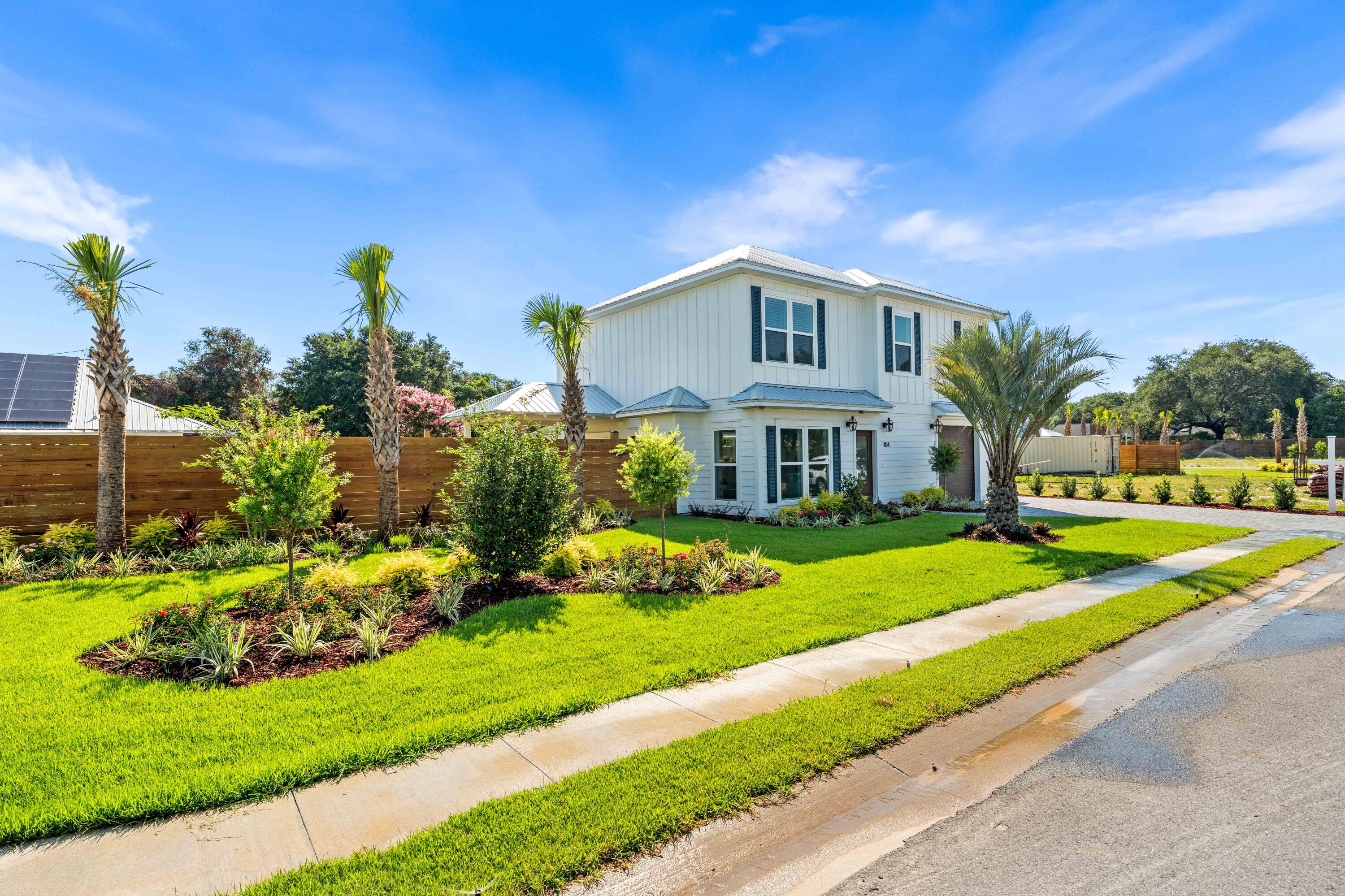 104 Fletcher Way Destin, FL 32541 - Photo 4 of 59 a front view of a house with a yard