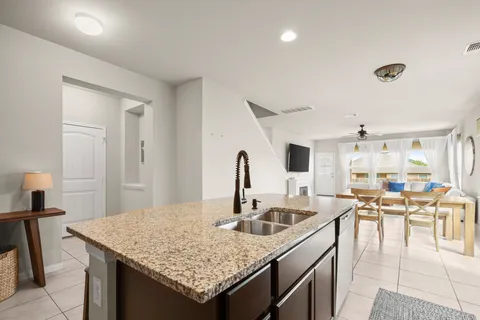a kitchen with stainless steel appliances granite countertop a stove top oven a sink a stove a dining table and chairs