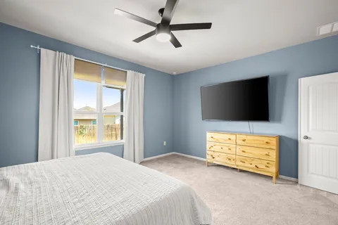 a bedroom with a bed and a ceiling fan