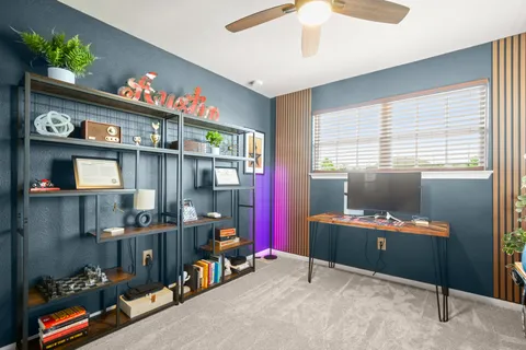 a view of a workspace with furniture and a window