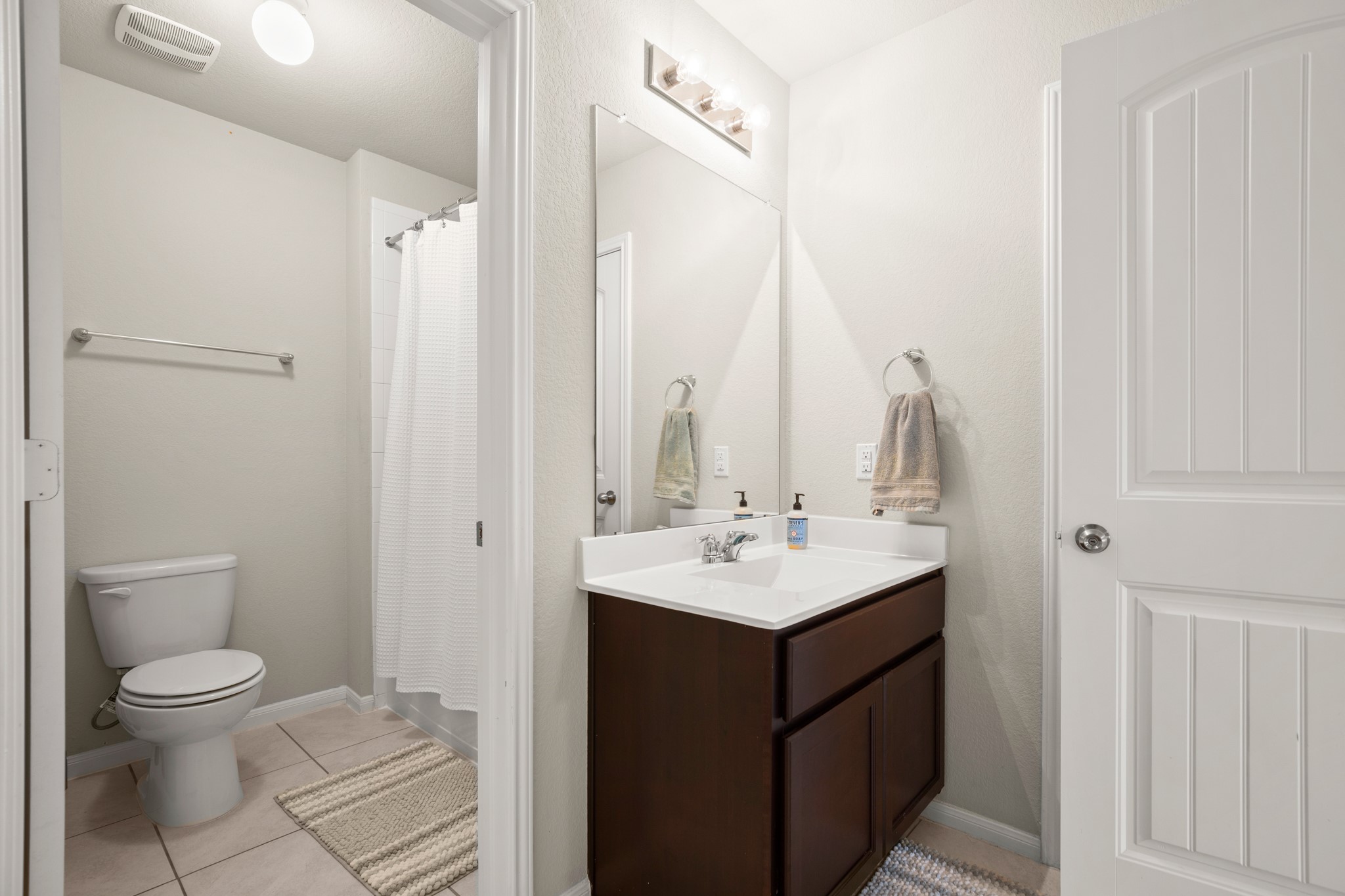 6520 Ranchito Drive Austin, TX 78744 - Photo 29 of 40 a bathroom with a toilet a sink and a mirror