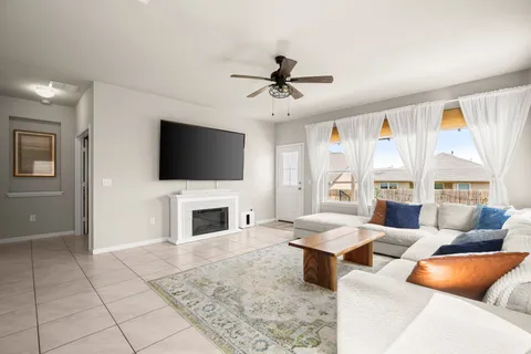 a living room with furniture a flat screen tv and a fireplace