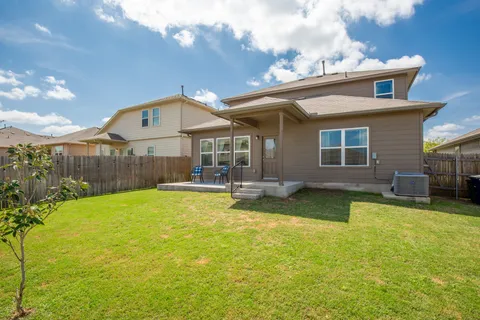 a view of a house with swimming pool and a yard