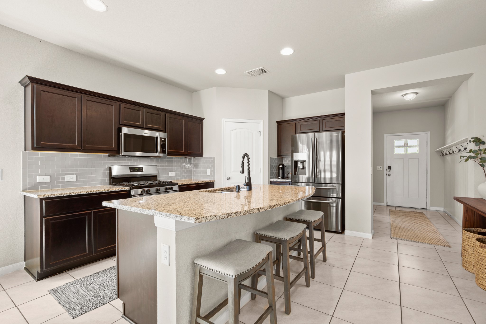 6520 Ranchito Drive Austin, TX 78744 - Photo 9 of 40 a kitchen with stainless steel appliances granite countertop a stove top oven a sink dishwasher a dining table and chairs