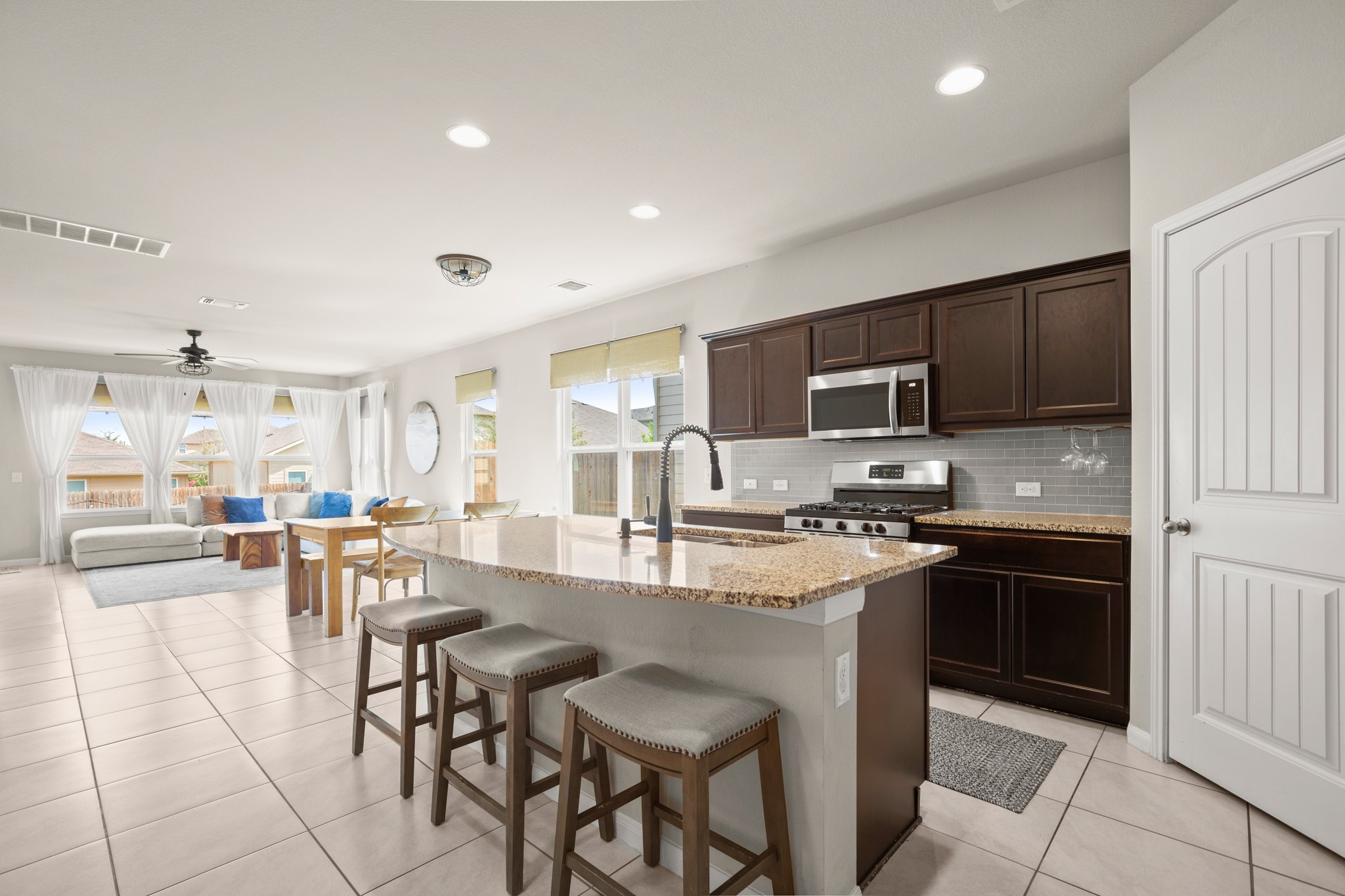 6520 Ranchito Drive Austin, TX 78744 - Photo 40 of 40 a kitchen with stainless steel appliances granite countertop a stove top oven a sink a stove a dining table and chairs