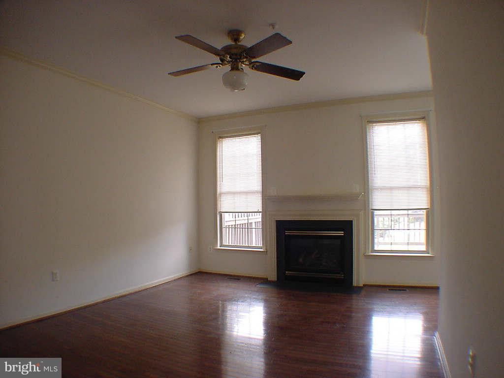 2430 Rippling Brook Road Frederick, MD 21701 - Photo 11 of 30 an empty room with wooden floor fireplace and windows