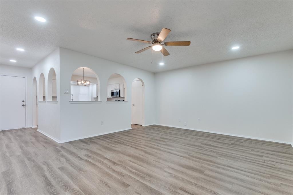 2308 West Oakdale Road Irving, TX 75060 - Photo 2 of 12 an empty room with wooden floor and windows