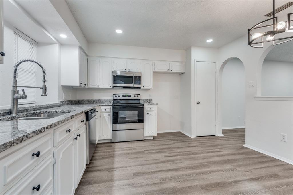 2308 West Oakdale Road Irving, TX 75060 - Photo 5 of 12 a kitchen with stainless steel appliances granite countertop a stove a sink and a refrigerator
