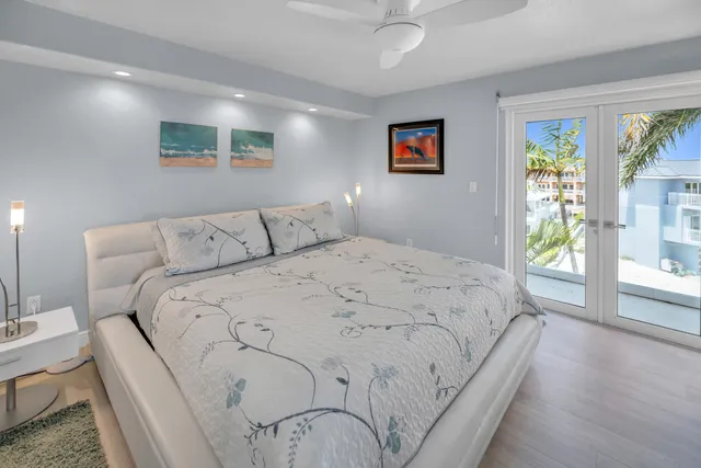 a bedroom with a large bed and a chandelier