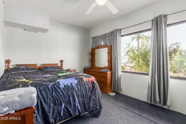 a bedroom with a bed and large windows