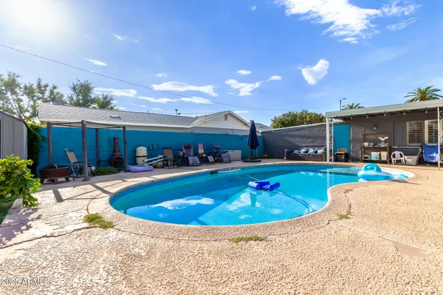 a view of a house with swimming pool and sitting area