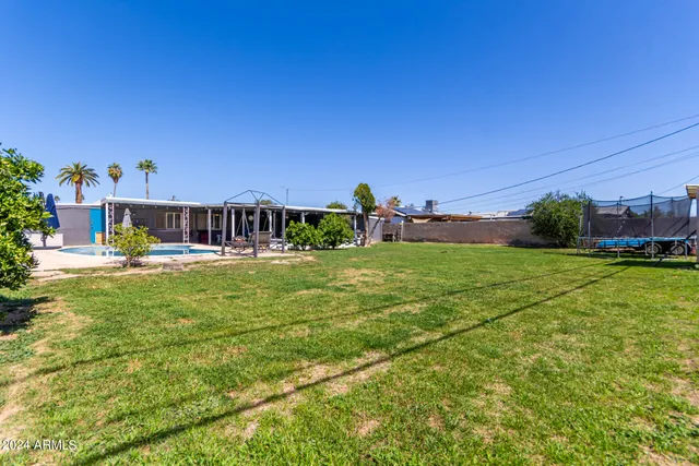 a house view with swimming pool in front of it
