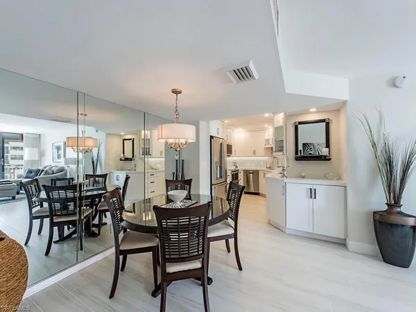 a dining area with a table chairs and a kitchen view