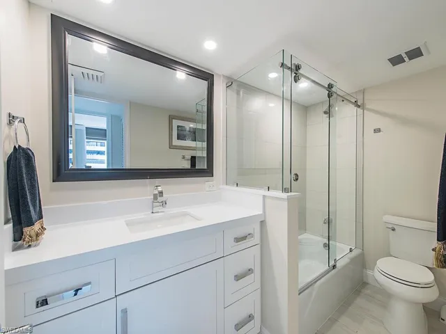 a bathroom with a sink a toilet a tub and a mirror