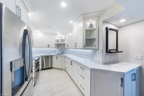 a kitchen with a sink refrigerator and cabinets