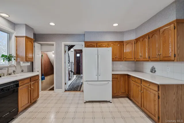 a kitchen with a refrigerator sink and cabinets