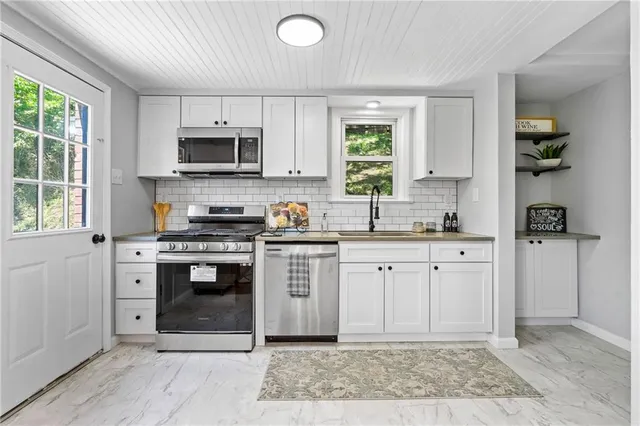a kitchen with stainless steel appliances granite countertop a stove a sink and a refrigerator